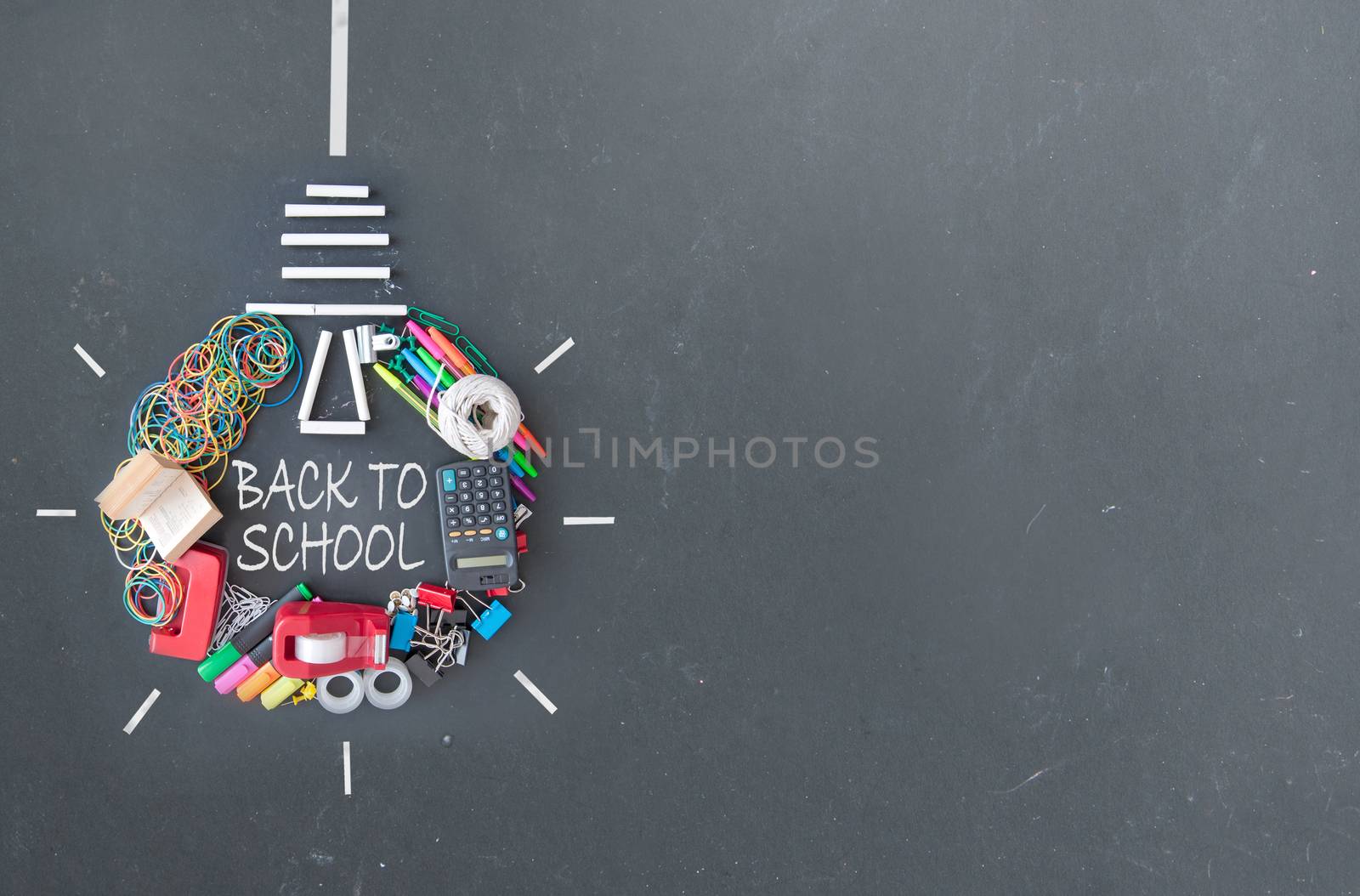 Light bulb icon 'hanging' made with many stationery accessories on a chalkboard