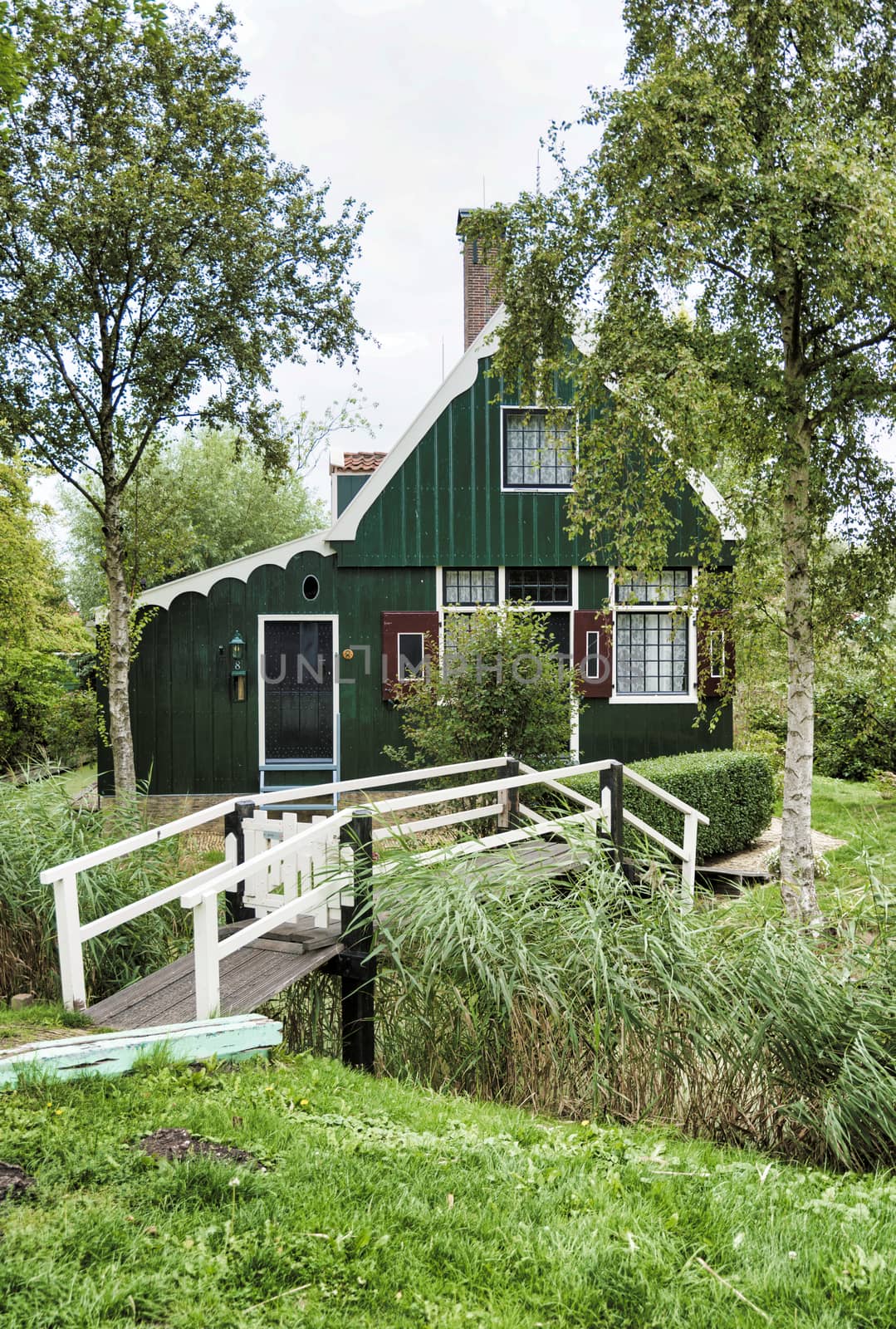 Zaandam,Holland,28-aug-2018:old green wooden houses from few hundred years oldstill  original and still inhabited, with a green bridge over the small rivers. this part is called zaanmse schans