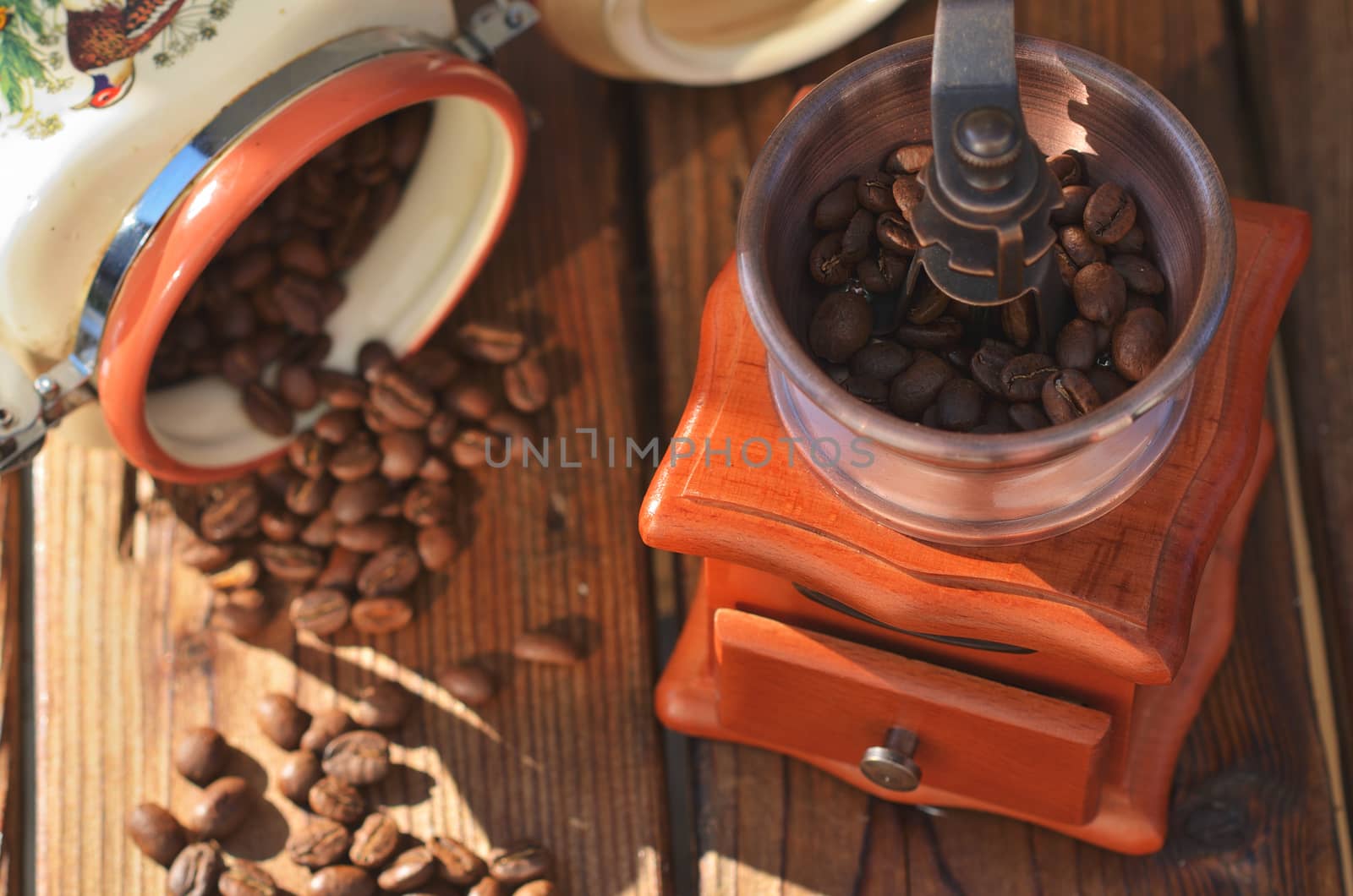 A handmade coffee grinder with coffee beans, coffee roasted grains poured out of the cans
