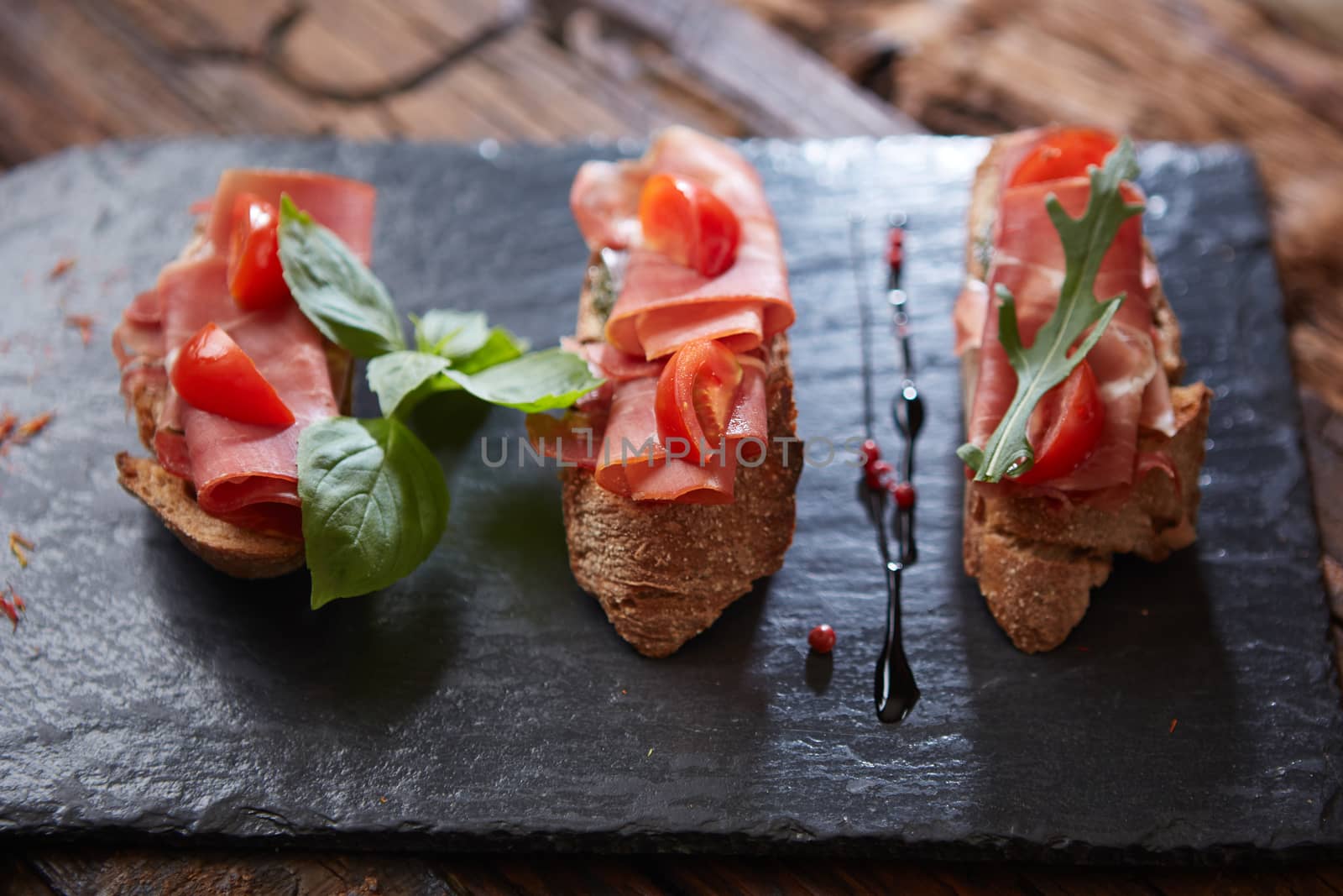 Bruschetta with hamon and sauce on black stone