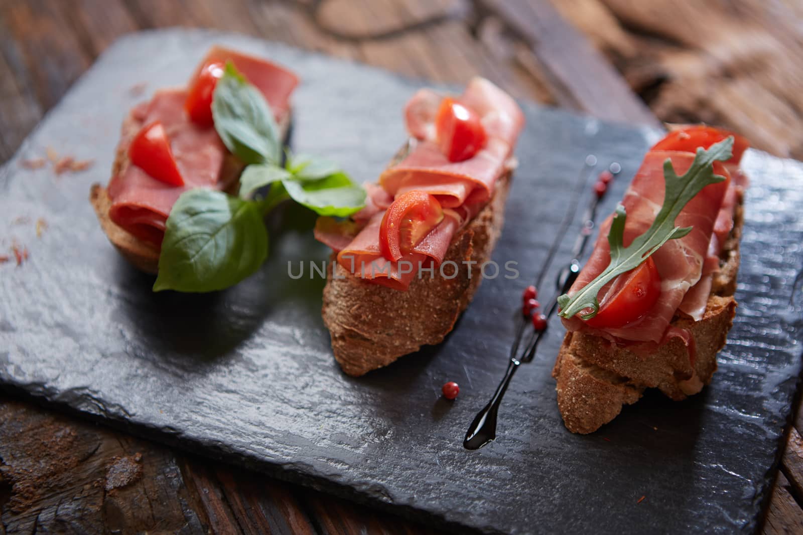 Bruschetta with hamon and sauce on black stone