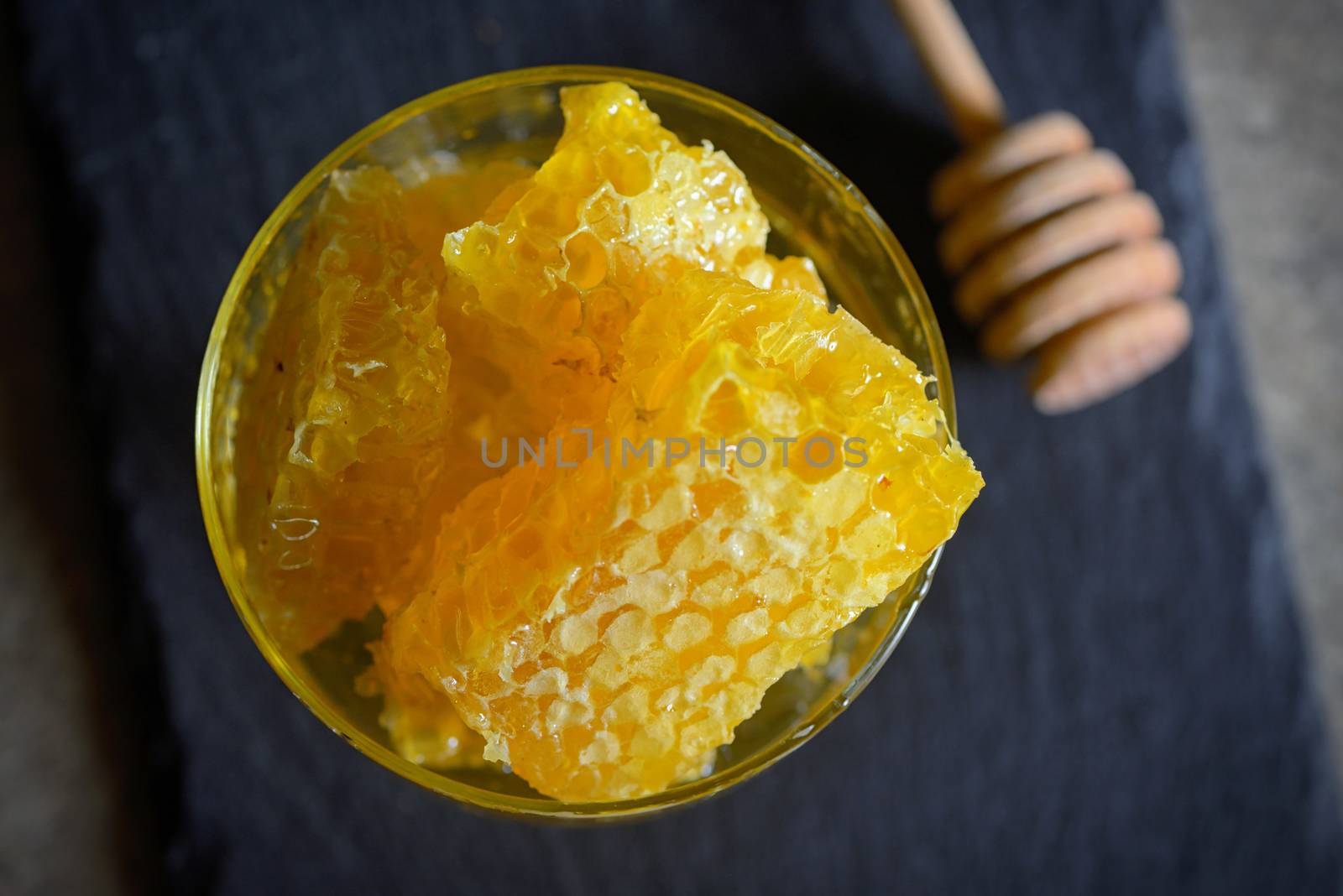 Fresh Honeycomb in glass and honey stick