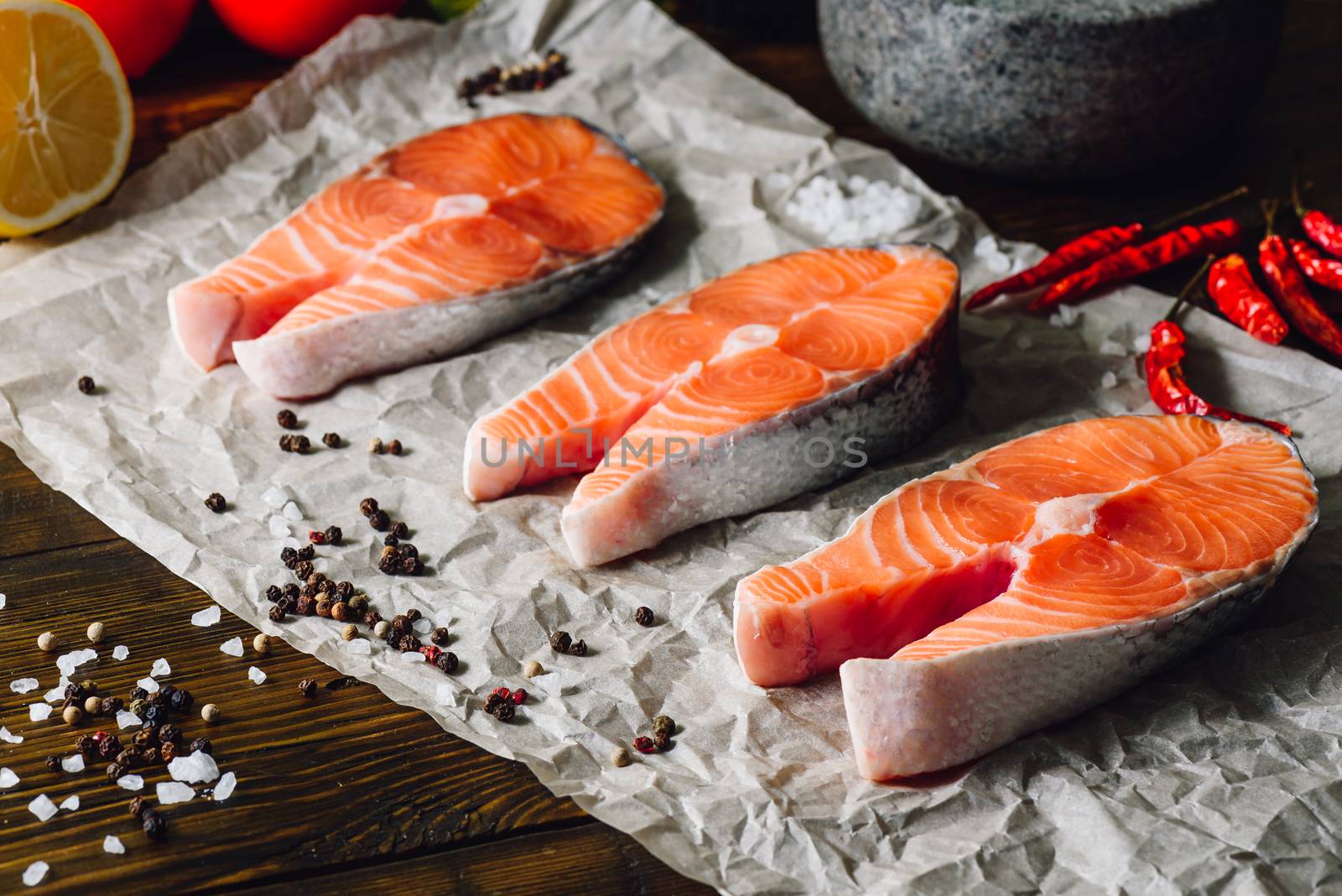 Three Raw Salmon Steaks with Some Spices.