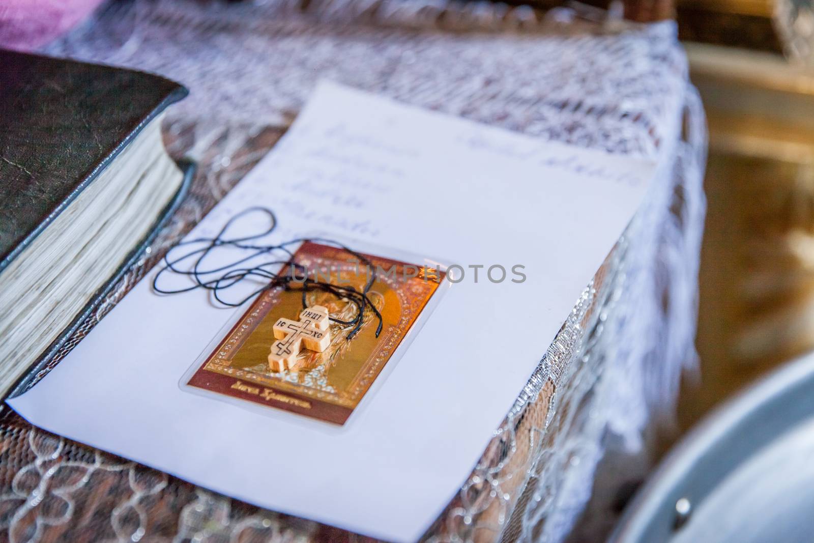 Small wooden cross with Bible on altar during christening