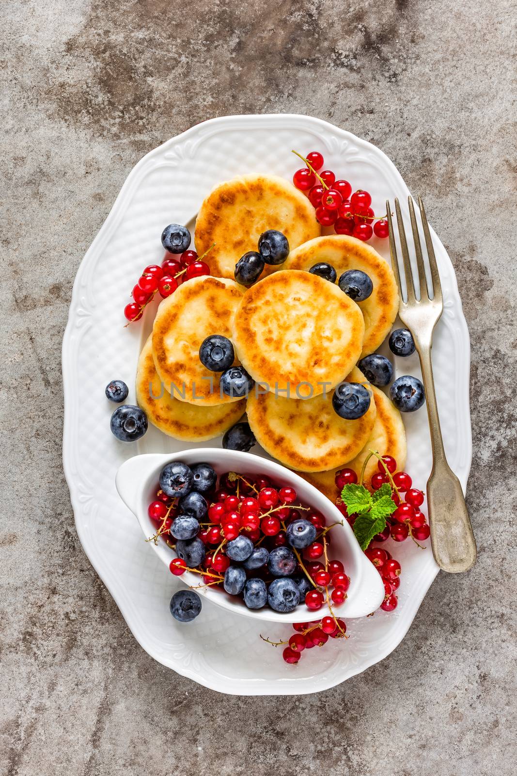 Cottage cheese fritters, pancakes with berries by yelenayemchuk