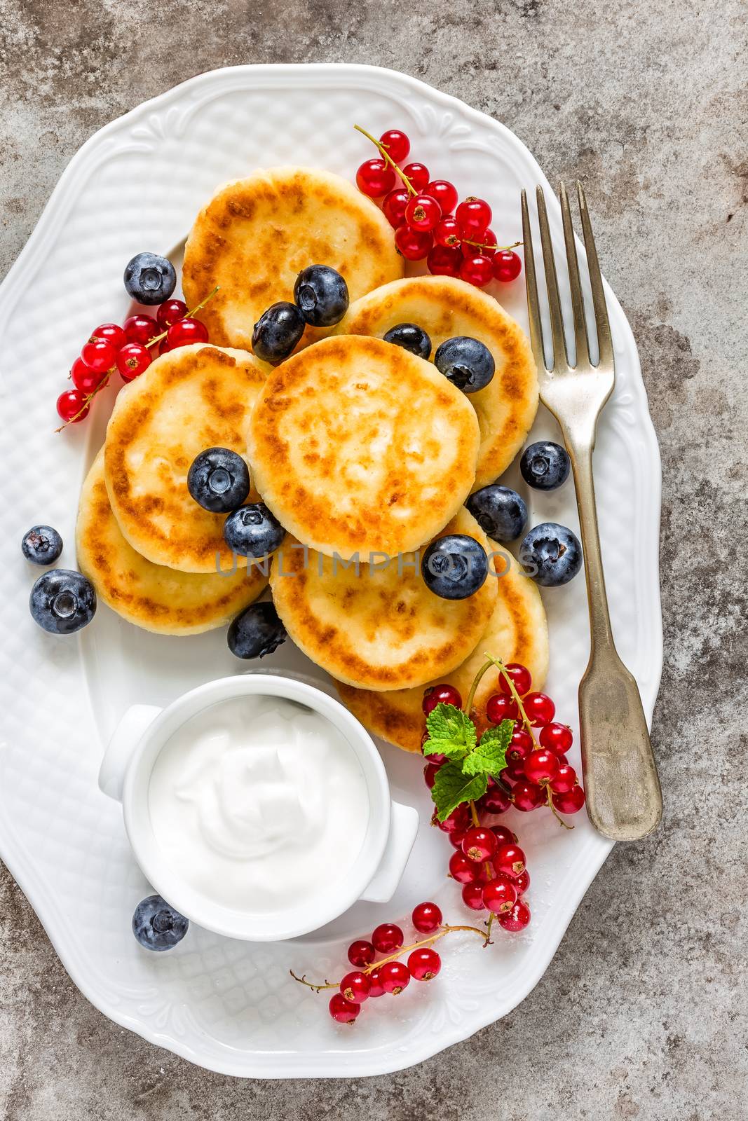 Cottage cheese fritters, pancakes with berries by yelenayemchuk