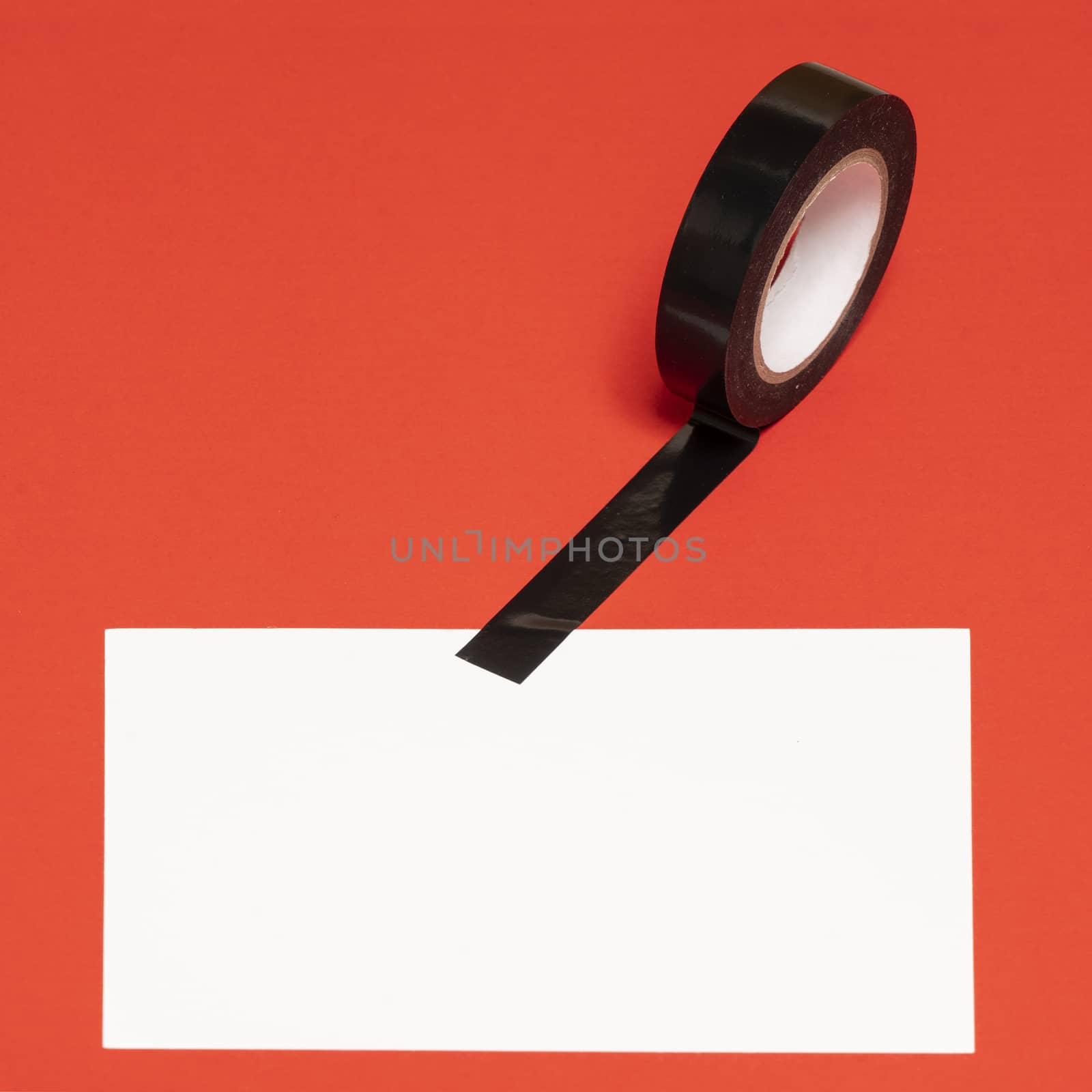 a white sheet attached to a red surface with black tape