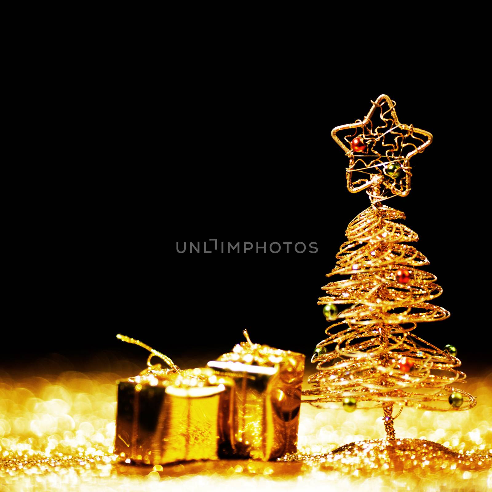 Toy golden decorative Christmas tree on glitter background