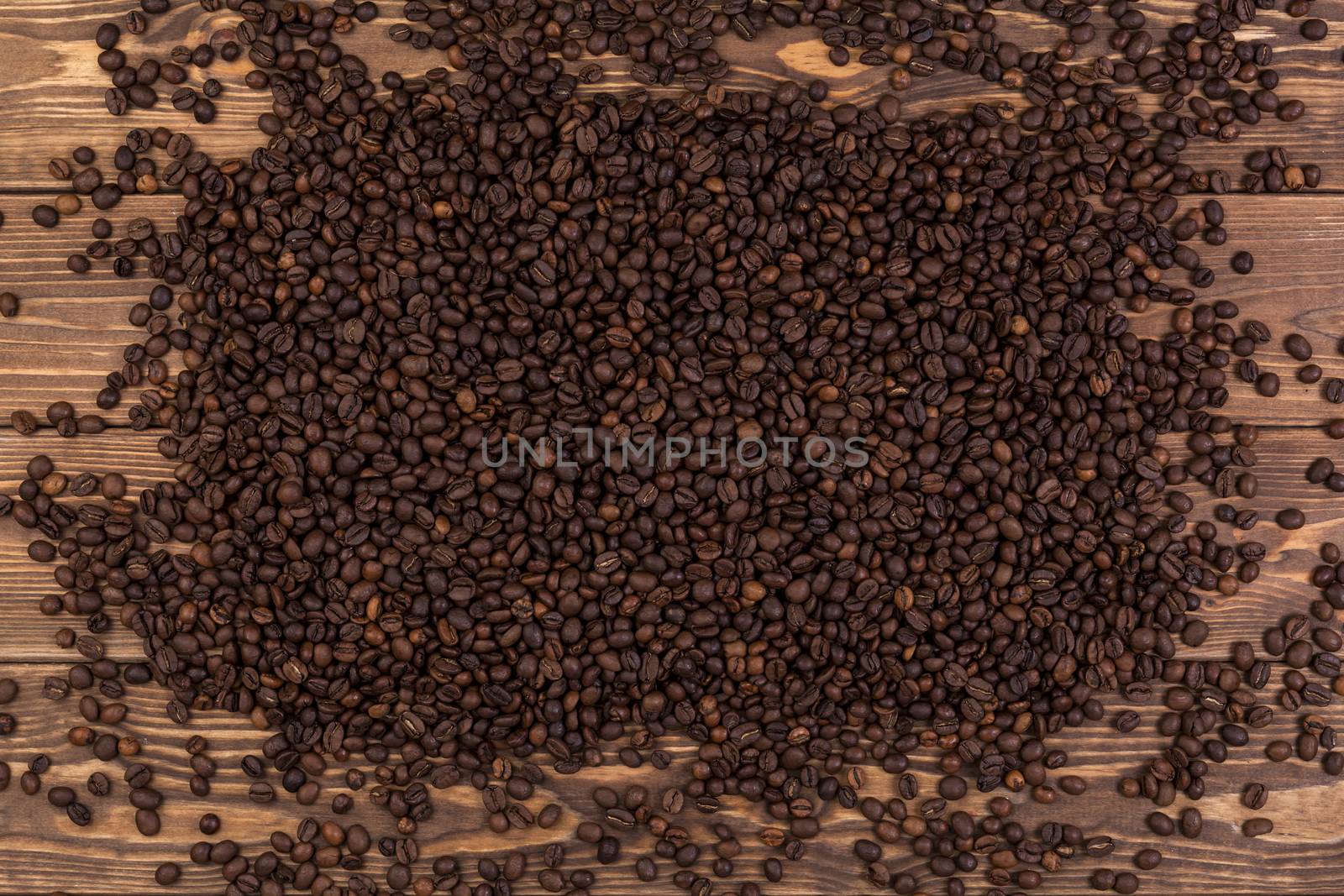 Coffee beans on brown wooden background, coffee texture, top view by xamtiw