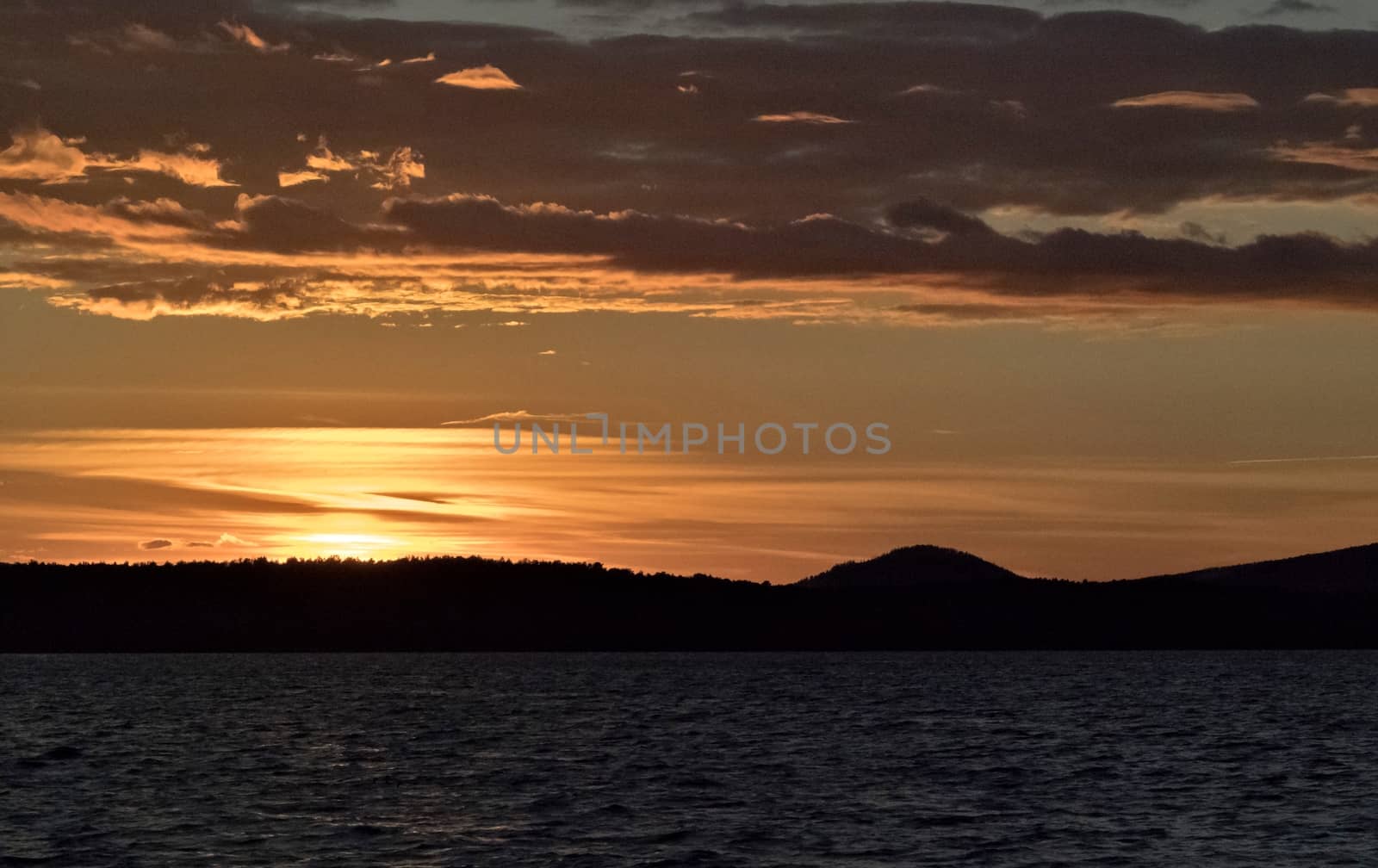 Golden sun sinks over the lake in the evening, golden water, South Ural lake Uvildy