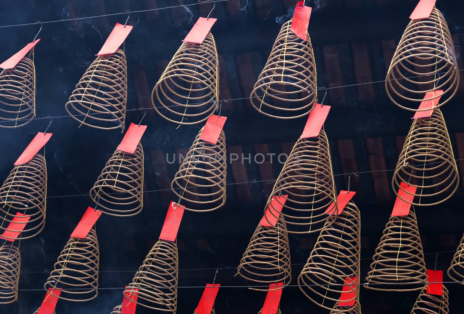 Spiral incense burning hanging from the ceiling in Vietnamese temple