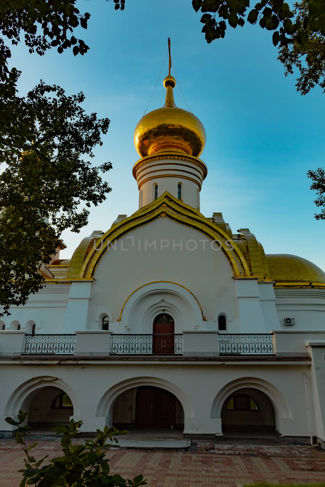 Beautiful view during sunset at the temple of St. Seraphim of Sarov in the city of Khabarovsk. A beautiful green lawn in the foreground. Religious architecture, buildings and traditions. Russia.