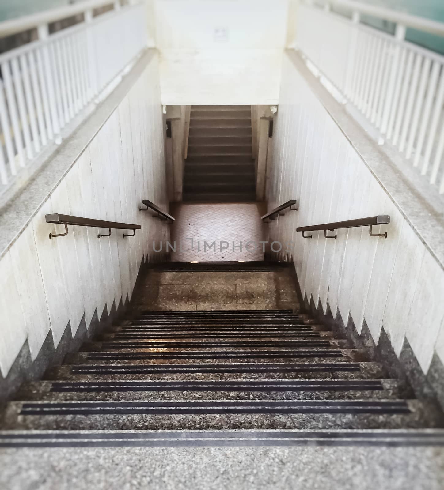 perspective view of a staircase with iron handrail and with a white balustrade