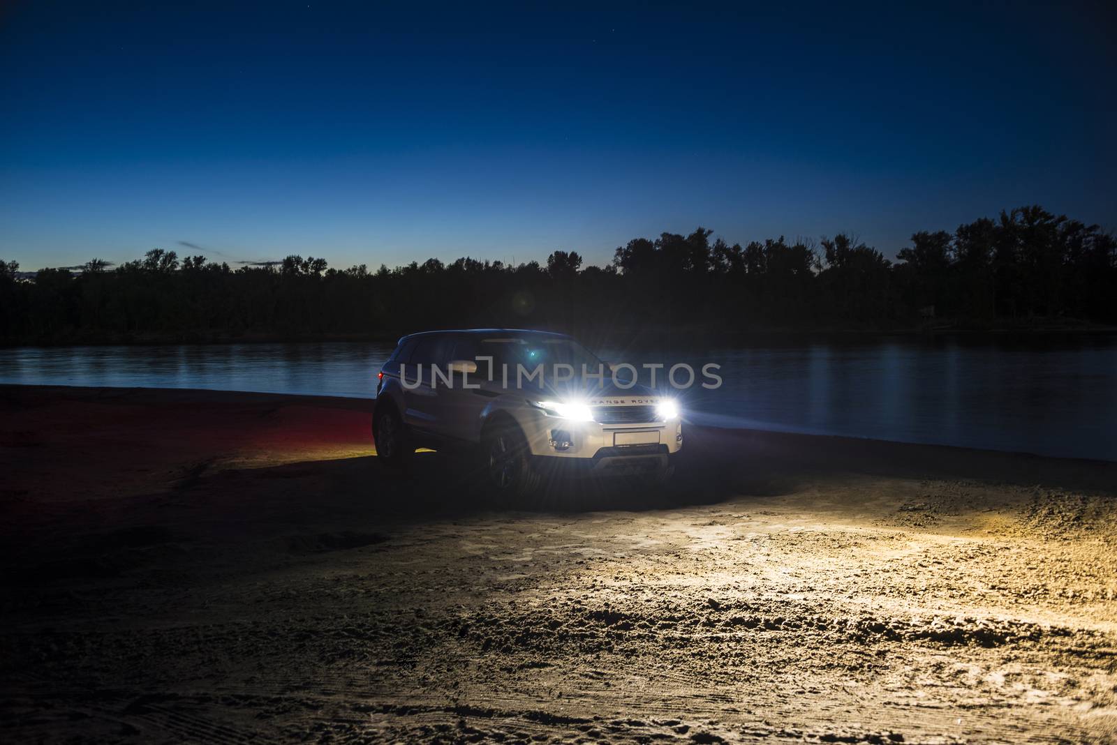 Car Land Rover Range Rover in the summer clear weather in the evening landscape of the Samara region, Russia. August 23, 2018..