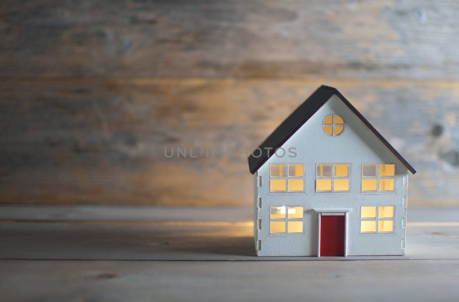 Miniature house over a wooden background by unikpix