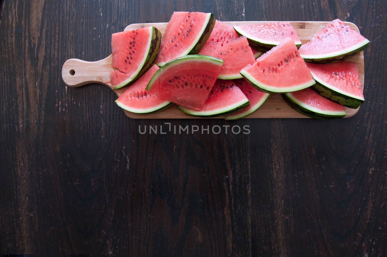 Fresh watermelon slices on top of a rustic wooden table