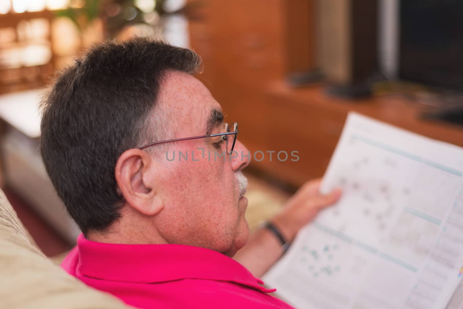Portrait of a senior man reading newspaper by HERRAEZ