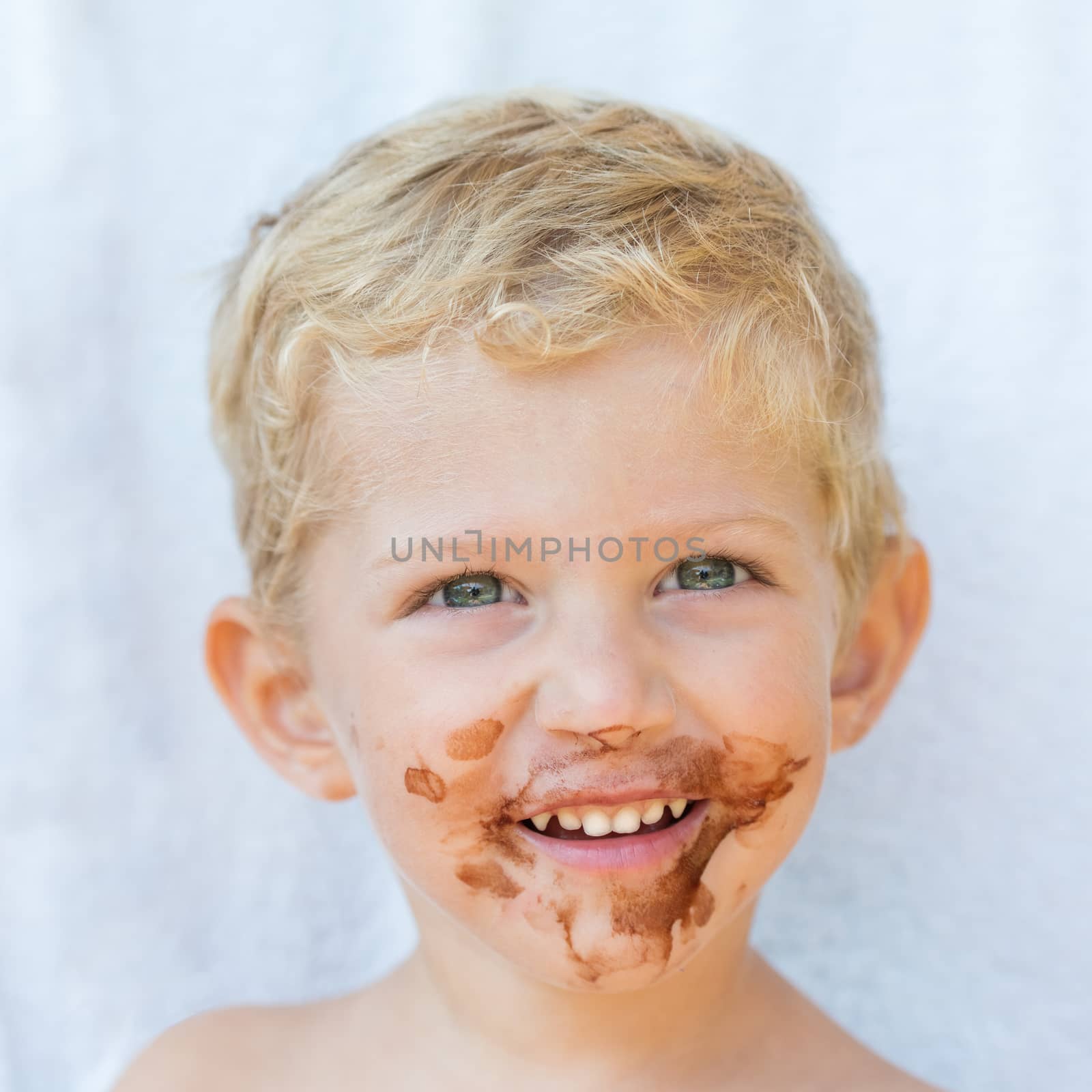 Portrait of fair-haired boy with chocolate on his face isolated on white background,baby boy smile,square photo.