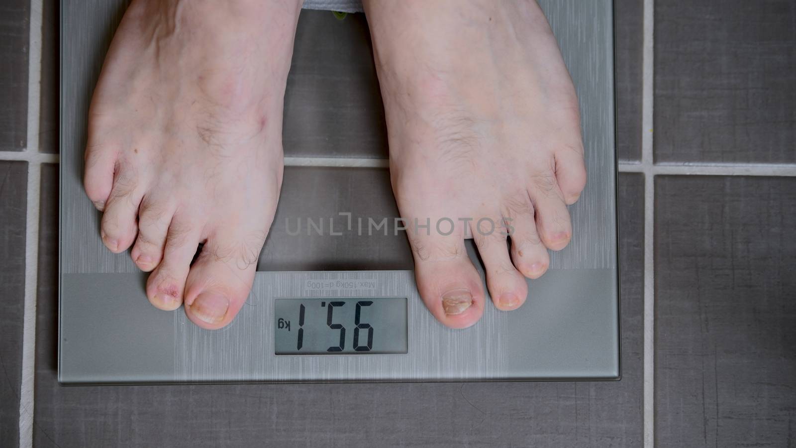 Male feet on glass scales, men's diet, body weight, close up, man standing on scale, top down view, athlete foot, medical, skin care