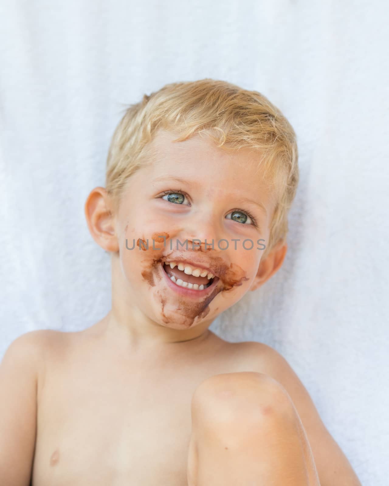 Portrait of fair-haired boy with chocolate on his face isolated on white background,baby boy smile