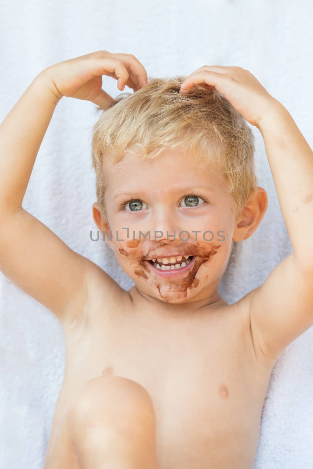 Portrait of fair-haired boy with chocolate on his face isolated on white background,baby boy smile.