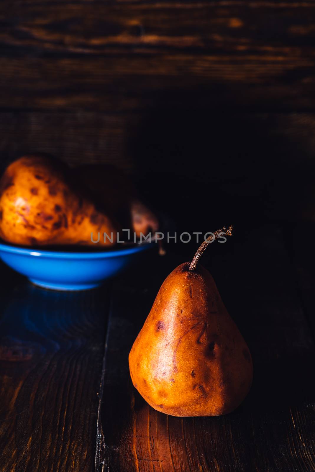 Golden Pear and Some Pears in Blue Bowl on Background
