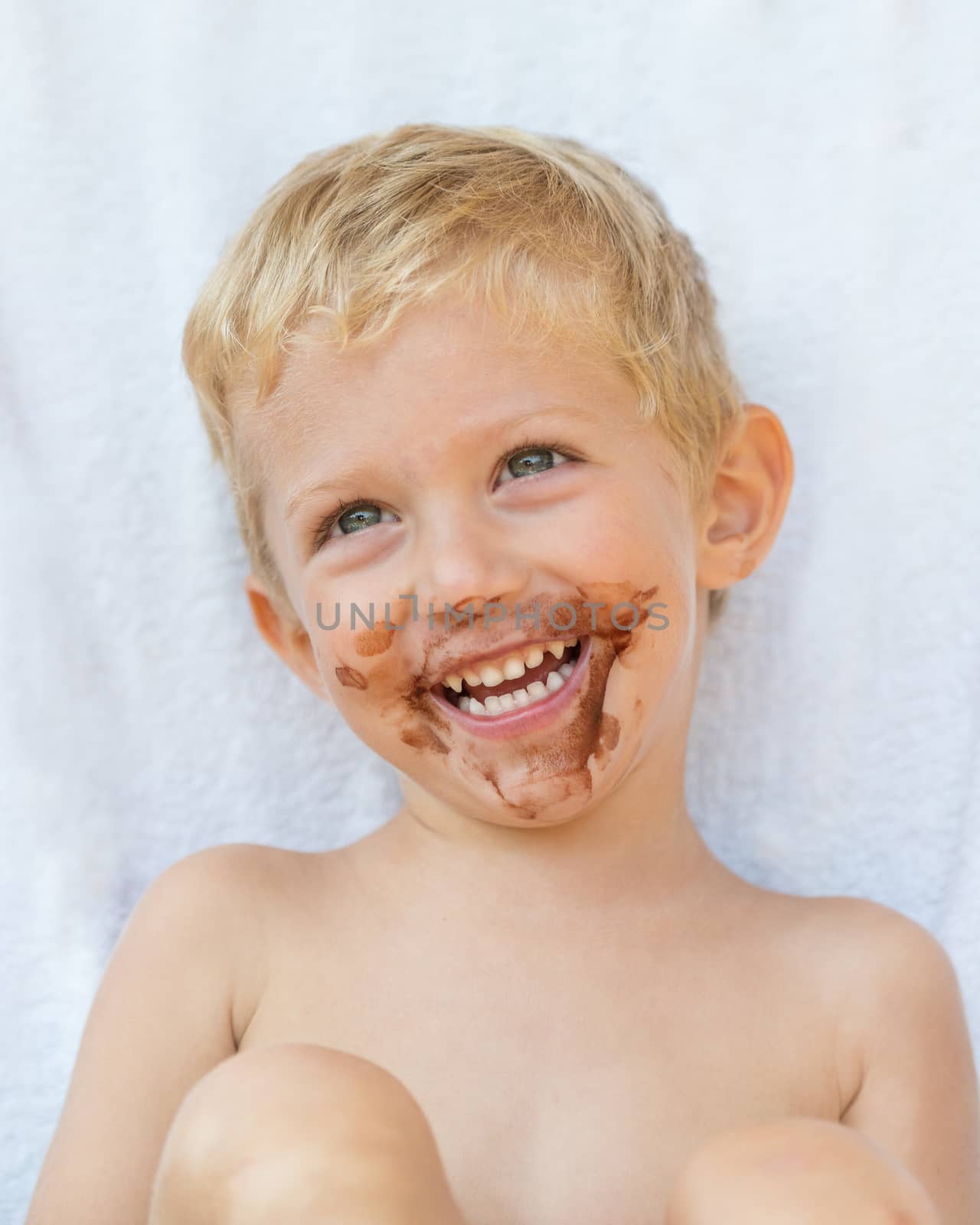 Portrait of fair-haired boy with chocolate on his face isolated on white background,baby boy smile.