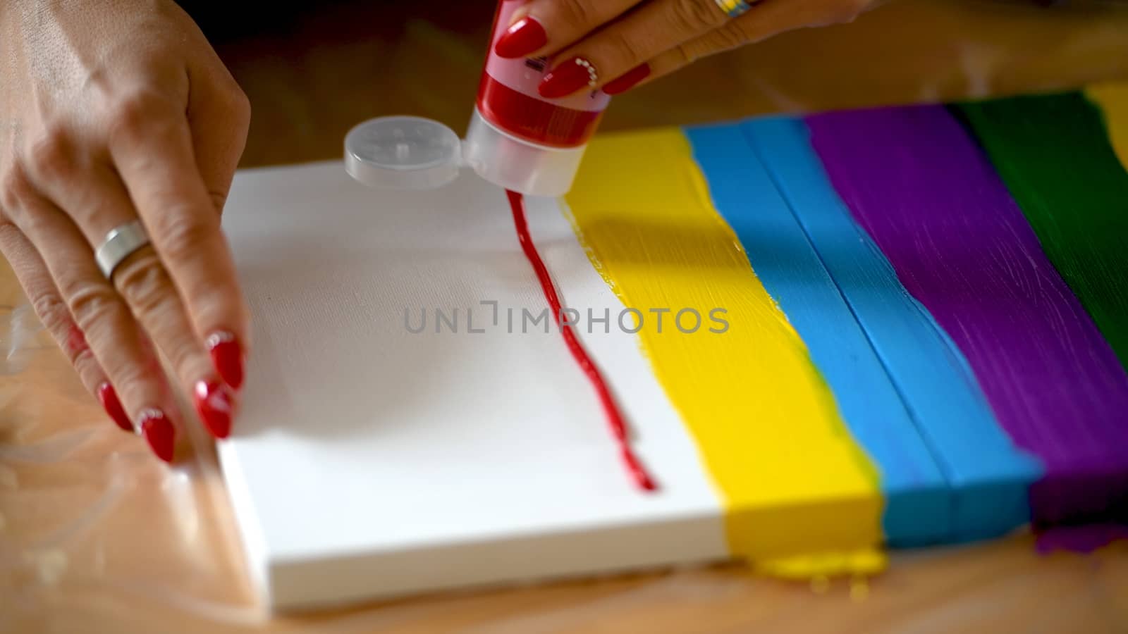 Female artist painting a rainbow with acrylic colors on canvas, hoe made art, DIY tutorial, colorful