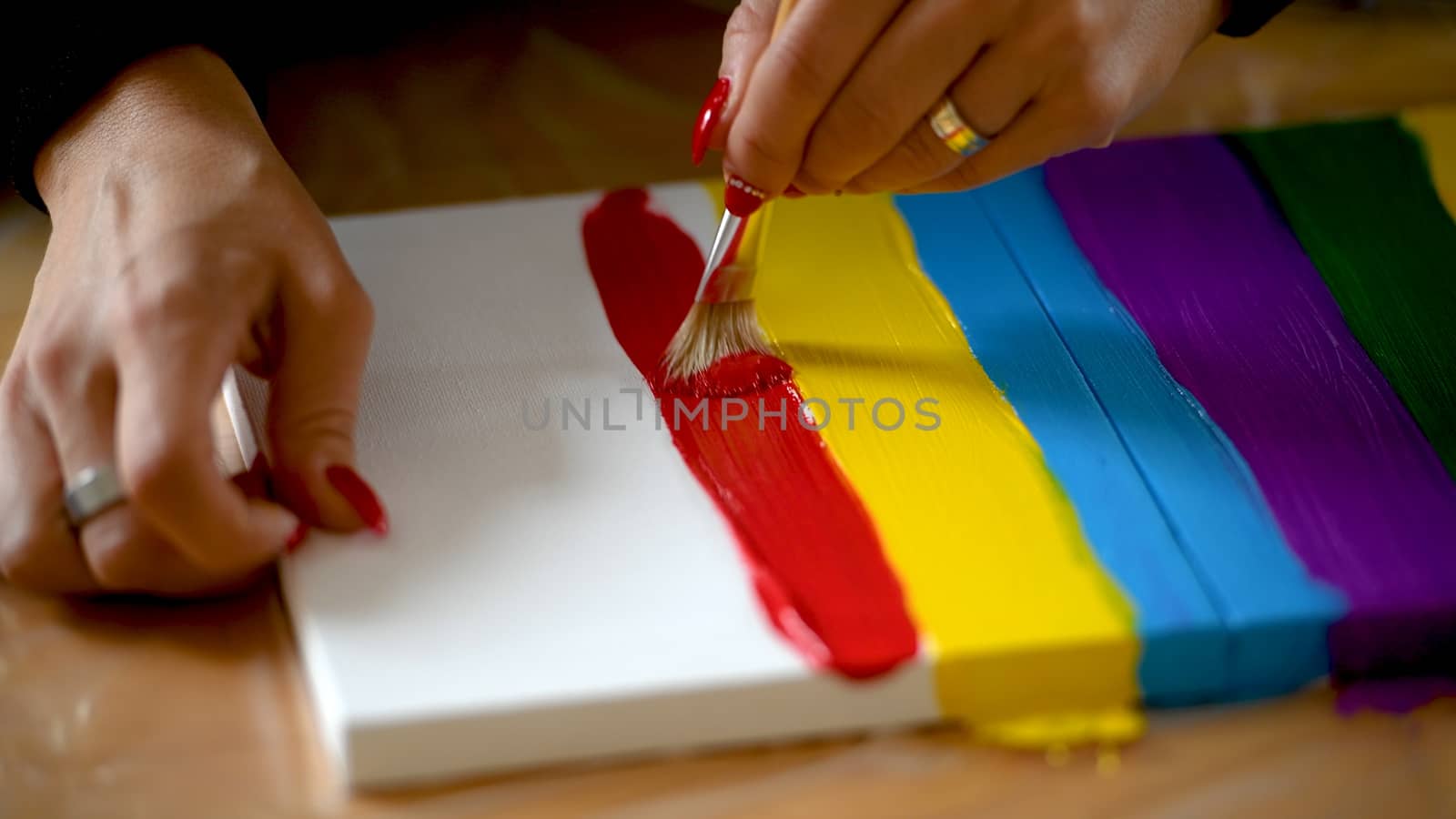 Female artist painting a rainbow with acrylic colors on canvas, hoe made art, DIY tutorial, colorful