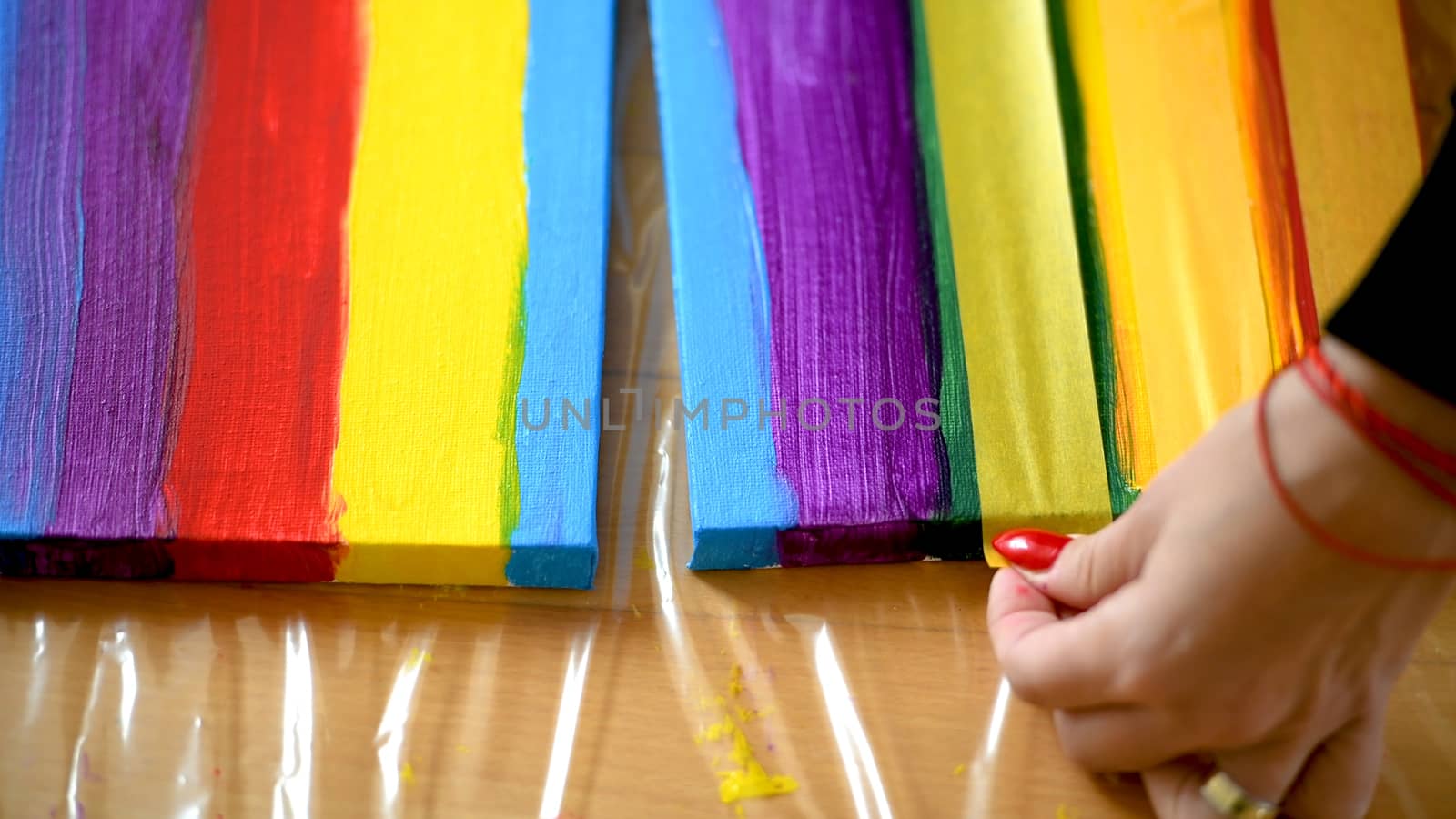 Female artist painting a rainbow with acrylic colors on canvas, hoe made art, DIY tutorial, colorful