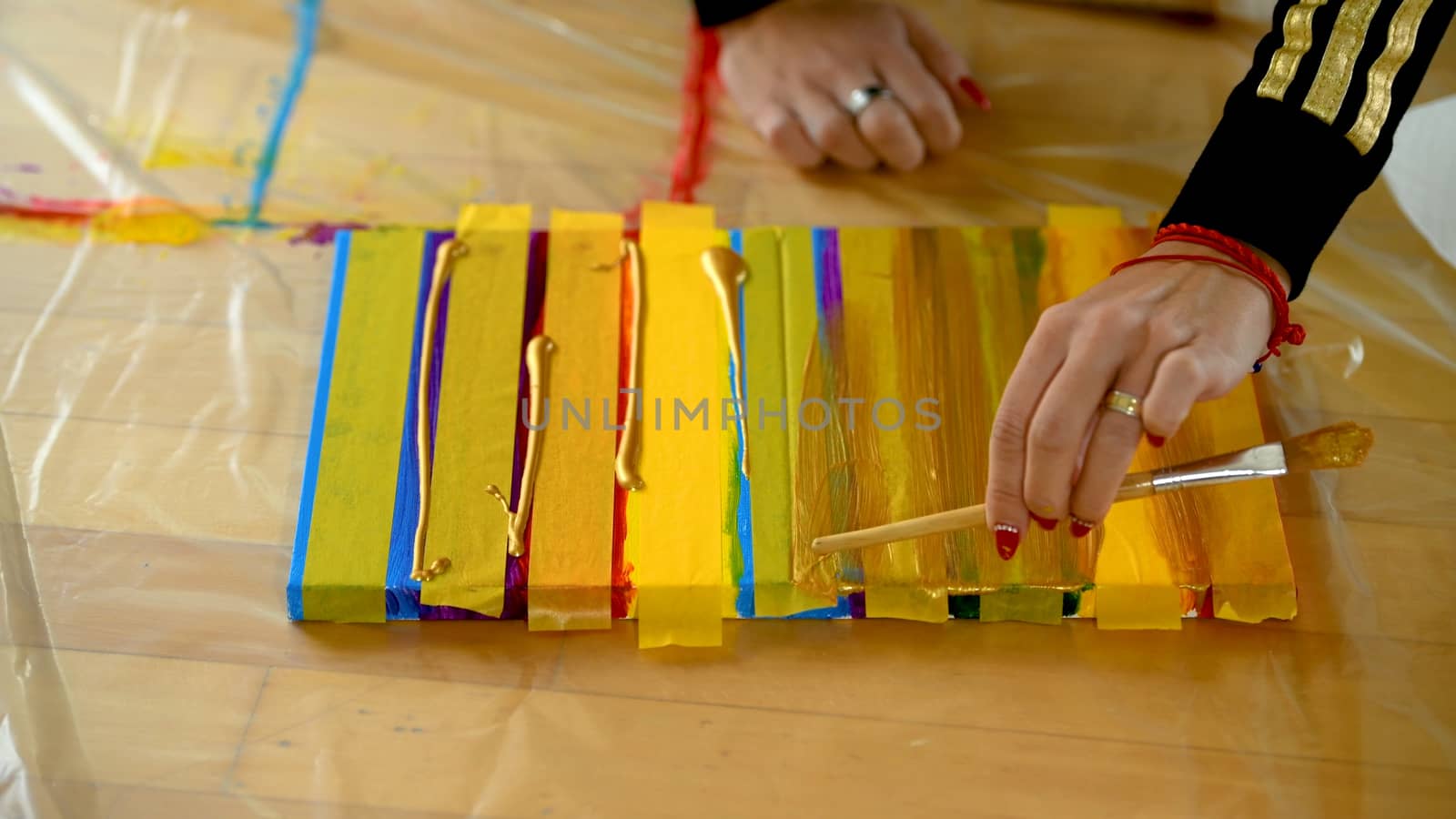 Female artist painting a rainbow with acrylic colors on canvas, hoe made art, DIY tutorial, colorful, painting with gold, tape mask for pattern