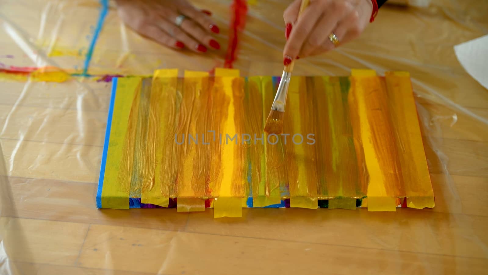 Female artist painting a rainbow with acrylic colors on canvas, hoe made art, DIY tutorial, colorful, painting with gold, tape mask for pattern