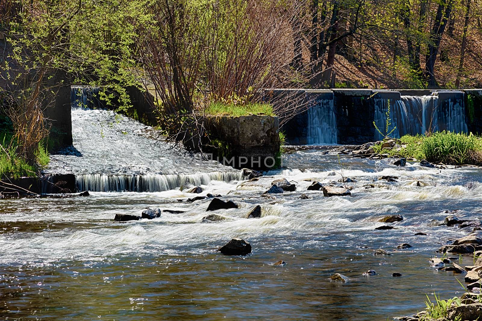 River with the weir runs over boulders