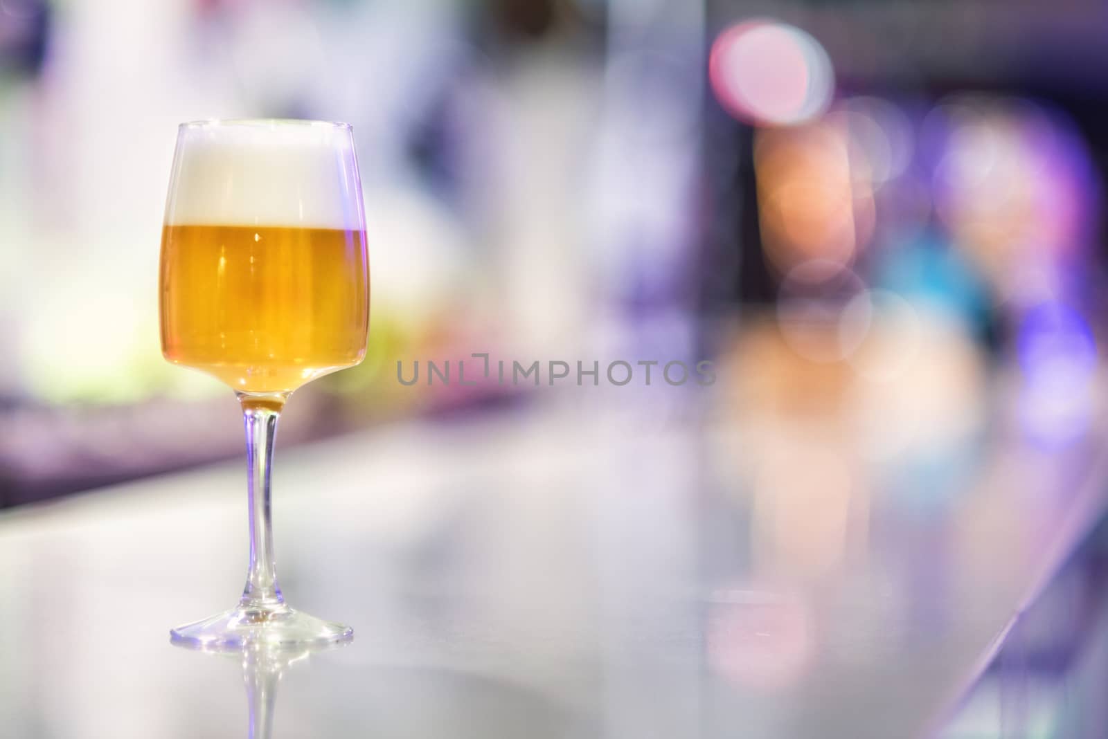 Glass of beer on modern pub counter by HERRAEZ