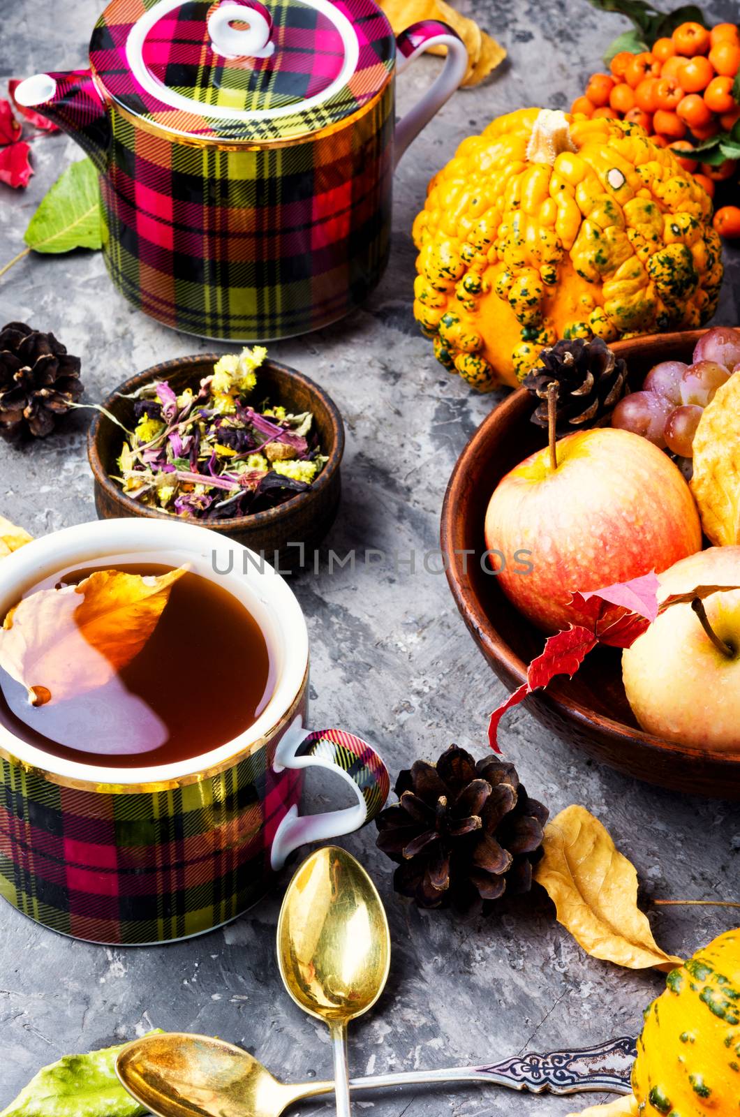 Teacup on an autumn background of fallen leaves and apples .Autumn postcard