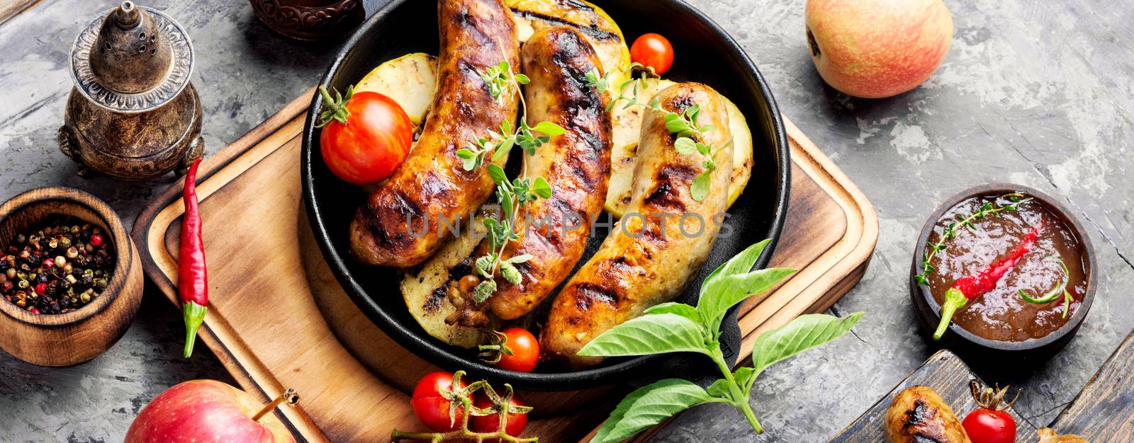 Delicious sausages grilled with spicy spices and apples.BBQ with sausages