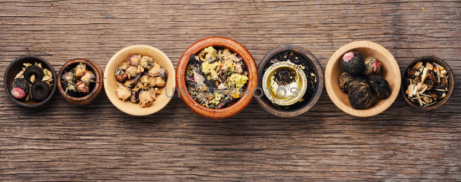 Mixture herbal floral tea in wooden mortar.Assortment of dry tea