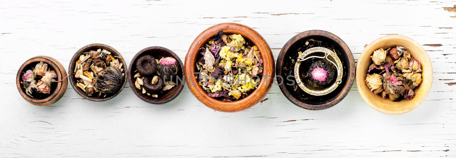 Mixture herbal floral tea in a wooden mortar.Food background