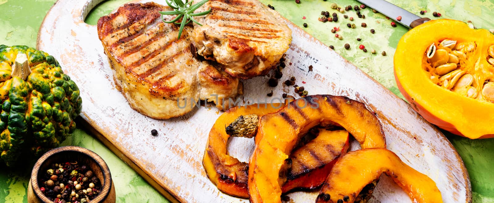 Baked meat with pumpkin on cutting board.Steak with pumpkin