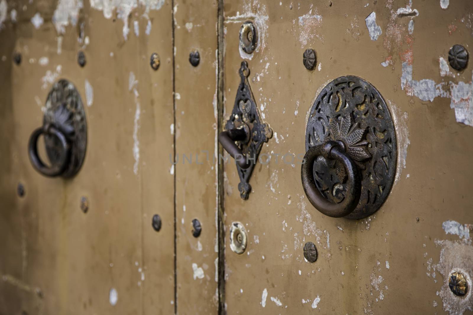 Wooden door with metal knockers, door detail of a decorated, safety and security