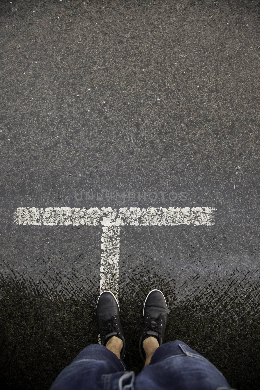 Feet on wet asphalt, rain detail