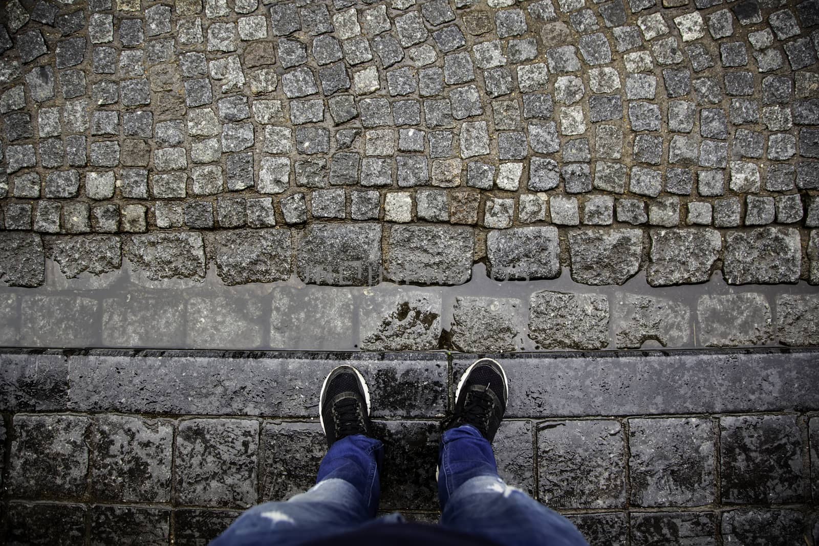 Tourist feet on cobblestones, detail of human feet in Europe