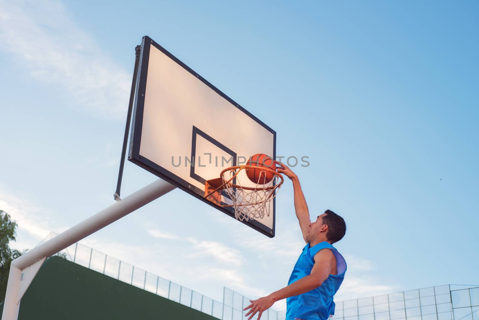 Basketball street player making a slam dunk by HERRAEZ