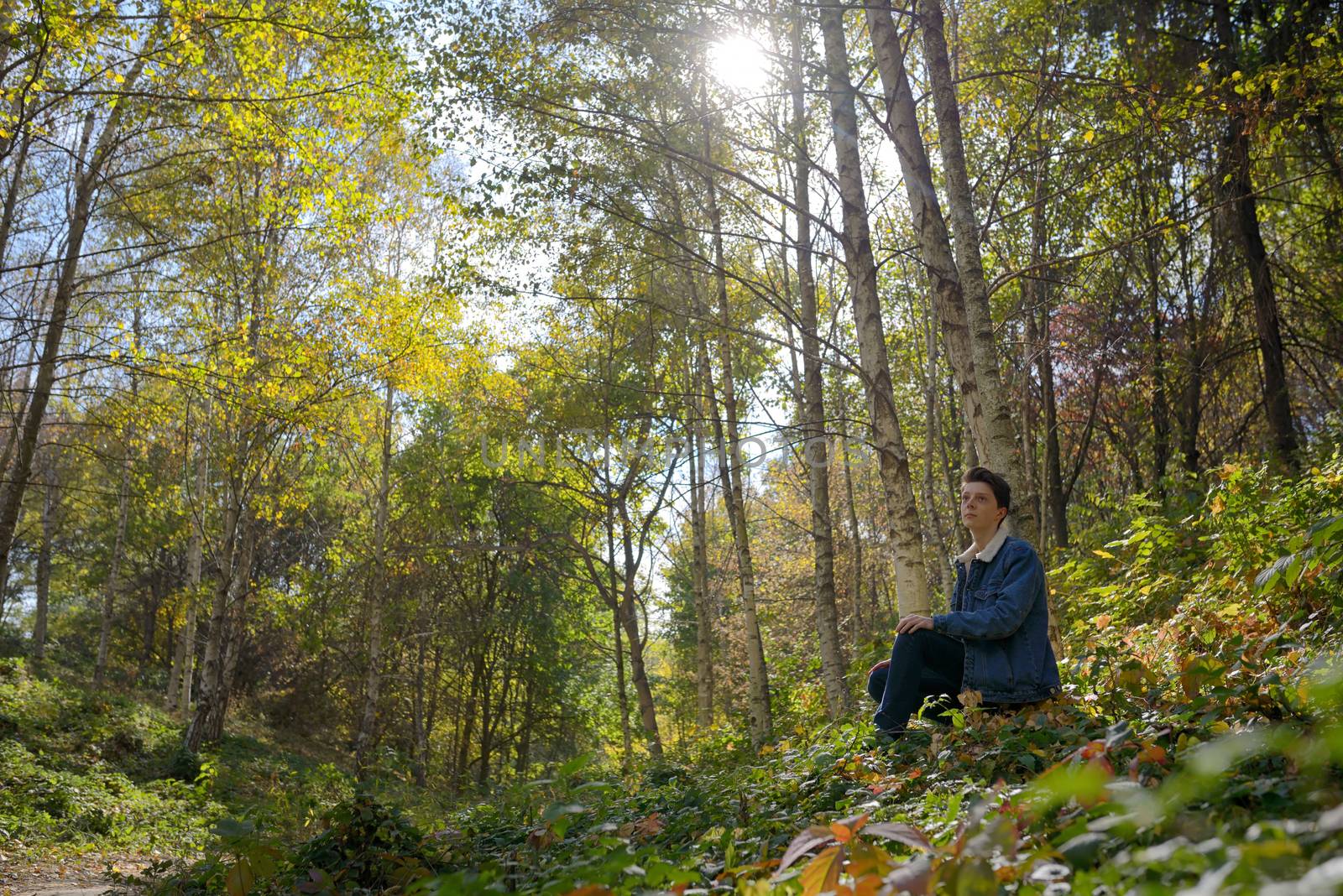 Youth boy alone in beautiful autumn forest