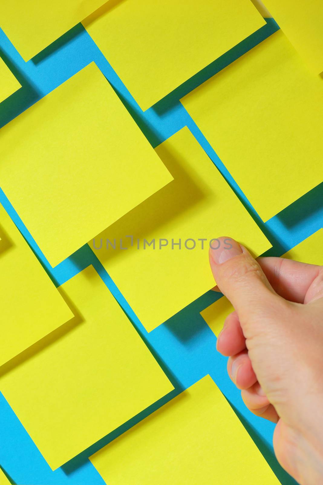 Hand holding post-it note on board