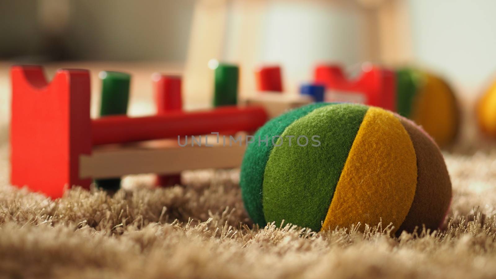 Colorful baby wood toys on light brown color carpet  by gnepphoto