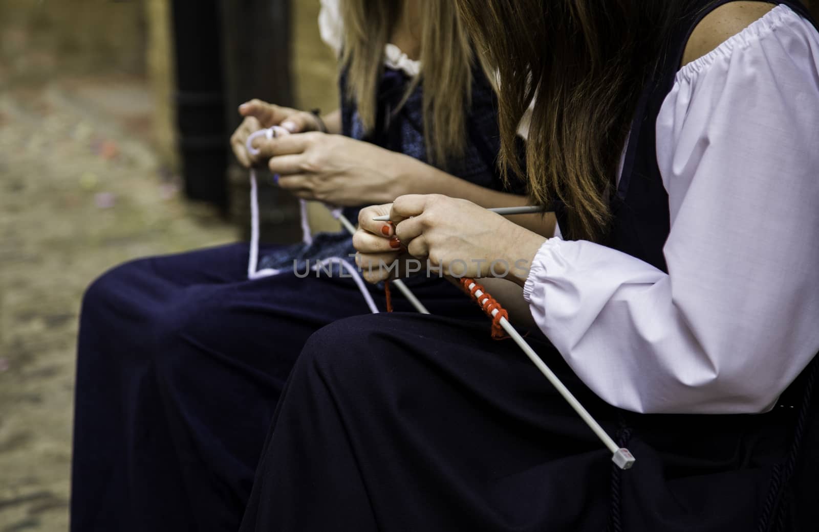 Young woman knitting clothes wool, detail of old tradition to make clothes