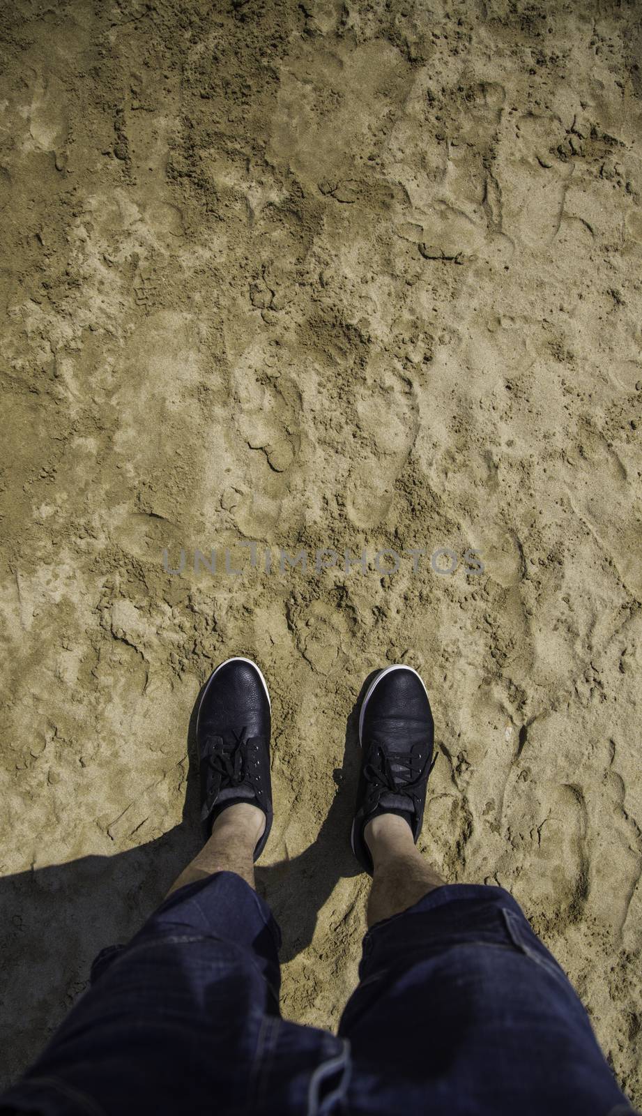 Feet with slippers on the beach, relaxing detail on the sea