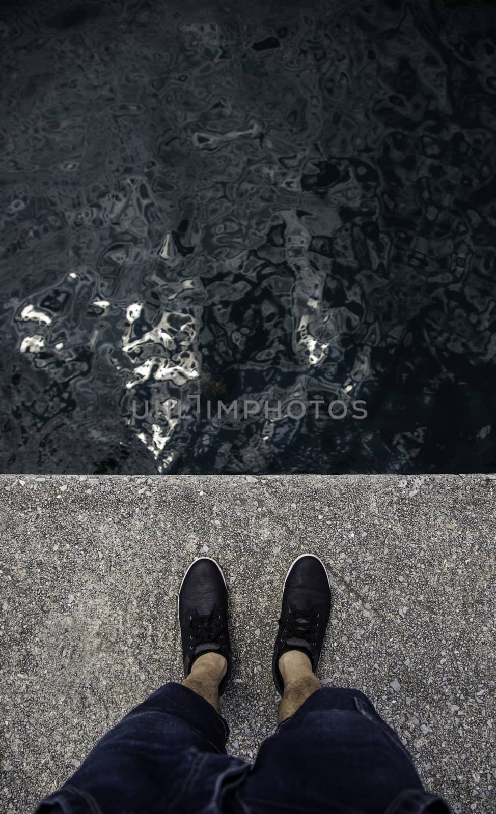 Feet on the water's edge, detail of exploration and contemplation