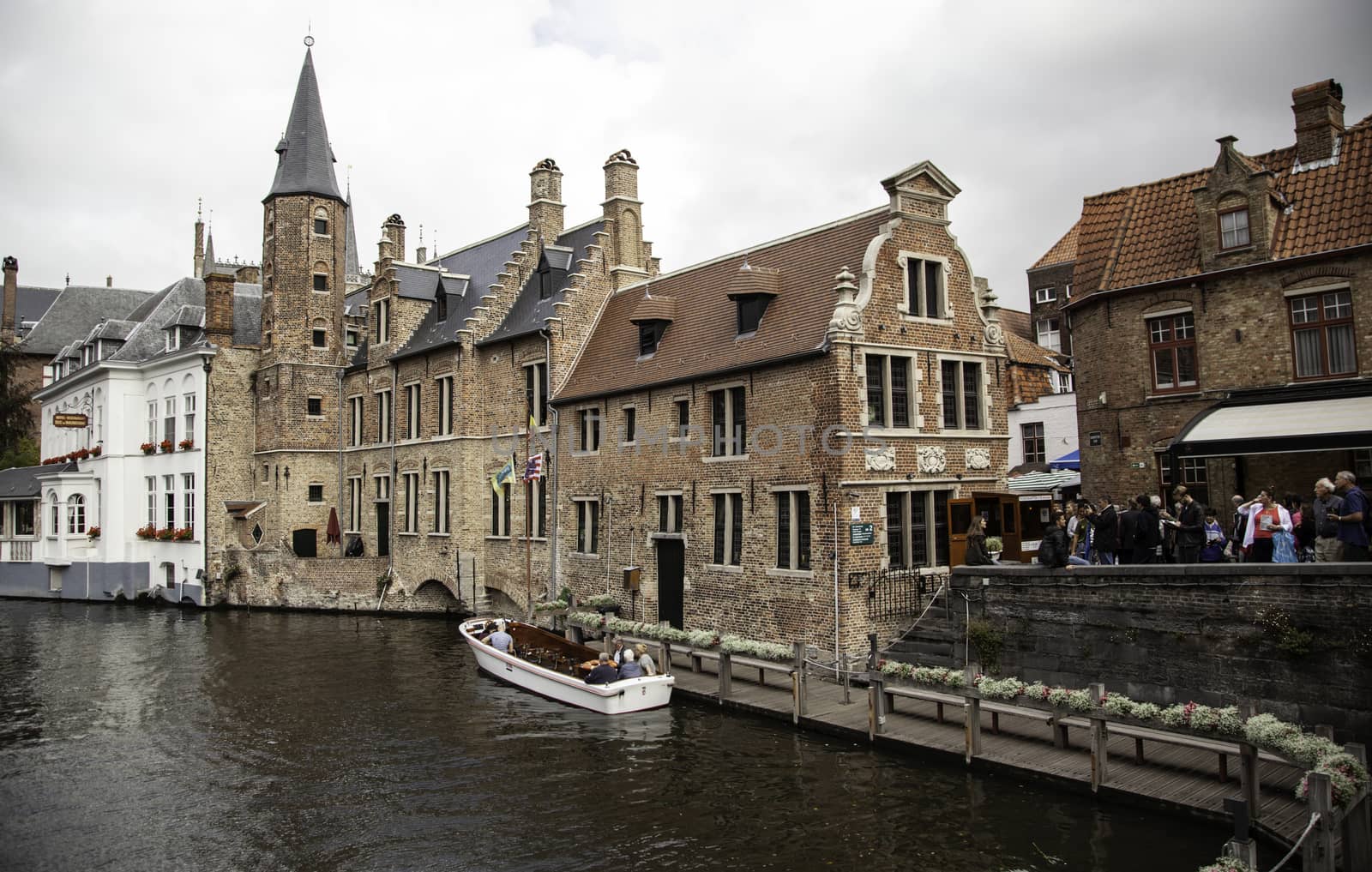 BRUGES, BELGIUM - SEPTEMBER 05, 2018: Canal in Bruges and famous Belfry tower on the background in a beautiful autumn day, Belgium on September 05, 2018